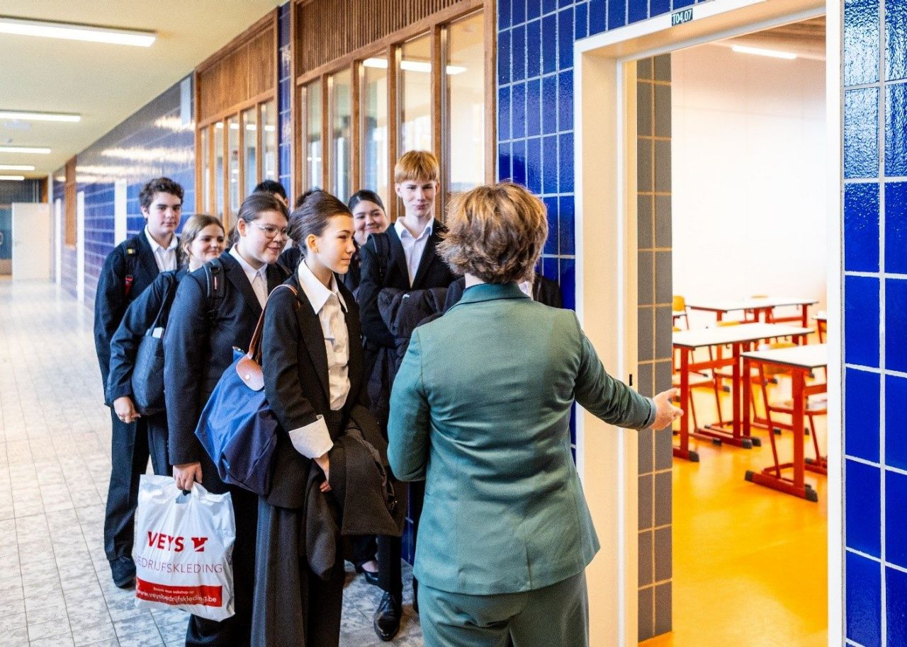 Leerlingen van het derde jaar wachten in rij aan de deur bij het begin van de les 